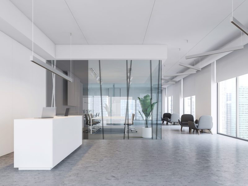 Interior of modern office with white walls, concrete floor, white reception table, meeting room with glass walls and lounge with armchairs. 3d rendering