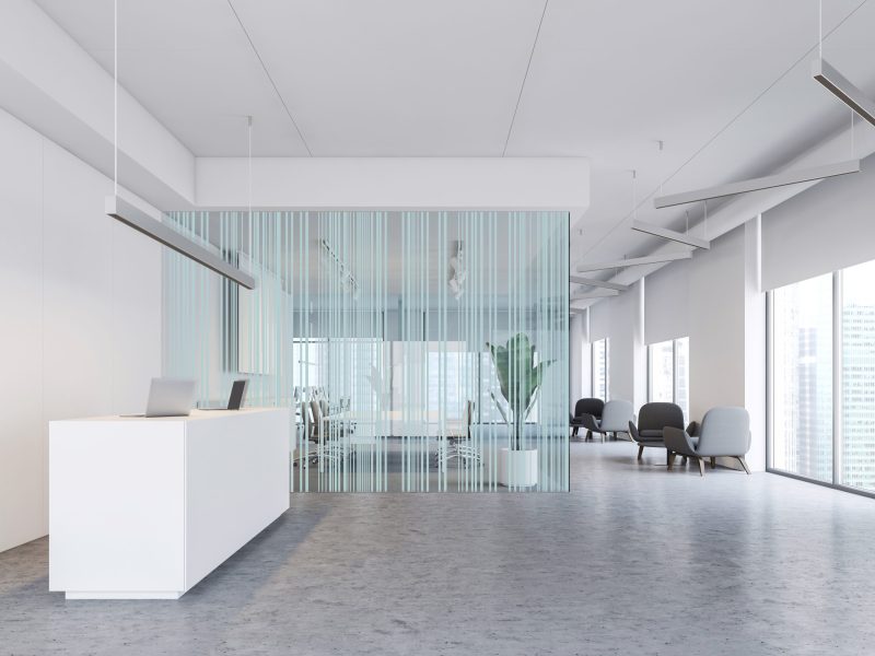 Interior of modern office with white walls, concrete floor, white reception table, meeting room with glass walls and lounge with armchairs. 3d rendering