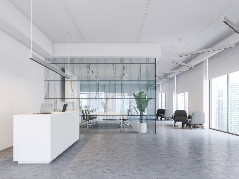 Interior of modern office with white walls, concrete floor, white reception table, meeting room with glass walls and lounge with armchairs. 3d rendering
