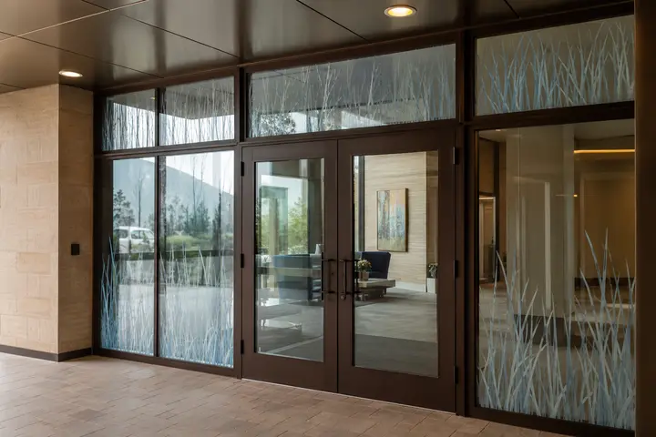 Ceramic-printed decorative glass sidelites and transoms at a sheltered commercial entrance