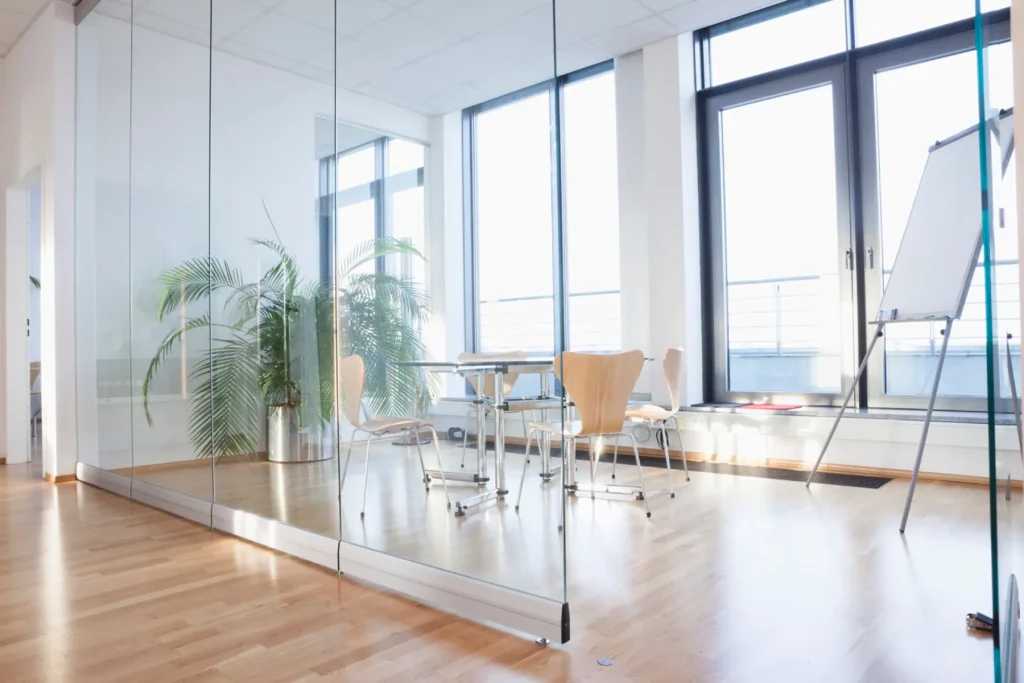 Bright commercial conference room enclosed by full-height glass partitions
