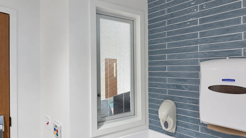 BetweenGlassBlinds installed in an interior window beside a handwashing station at AdventHealth Daytona Beach.