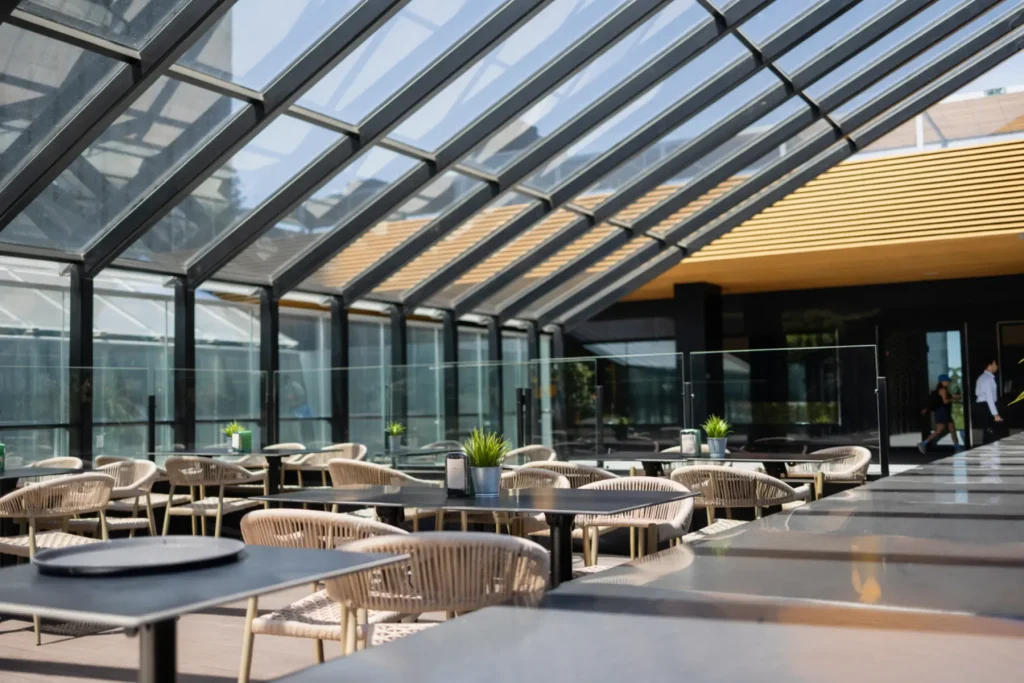 Bright hotel restaurant beneath an expansive architectural glass roof